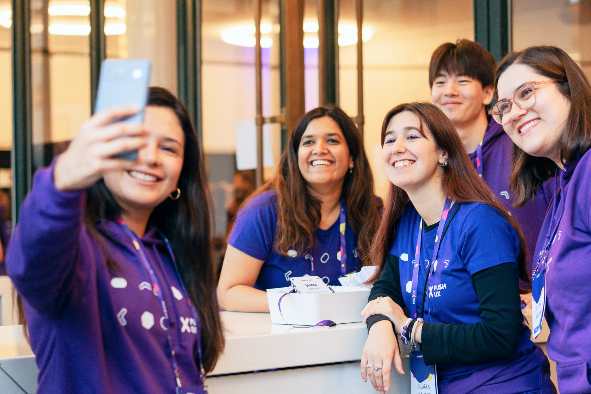 Group of PUSH UX volunteers taking a smiling selfie together at the registration desk.